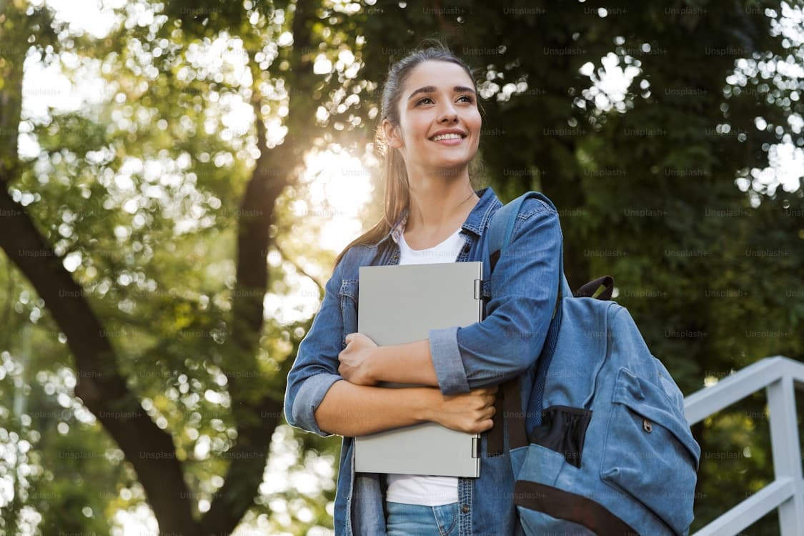 A student holding books outdoors